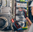 man-an-electrical-technician-working-in-a-switchboard-with-fuses - Новый Компаньон